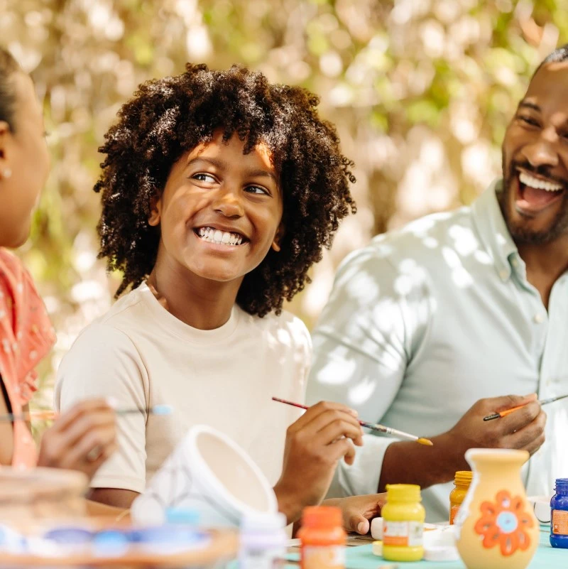 Family painting pottery in the park